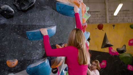 adolescentes haciendo bouldering en un gimnasio
