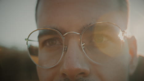 eyes close-up of an angry and serious caucasian young man with glasses having difficulty seeing