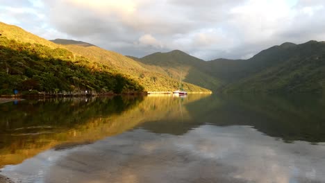 Incredible-early-morning-golden-hour-reflection-of-sea,-sky-and-land-from-secluded-cove---Camp-Bay,-Endeavour-Inlet