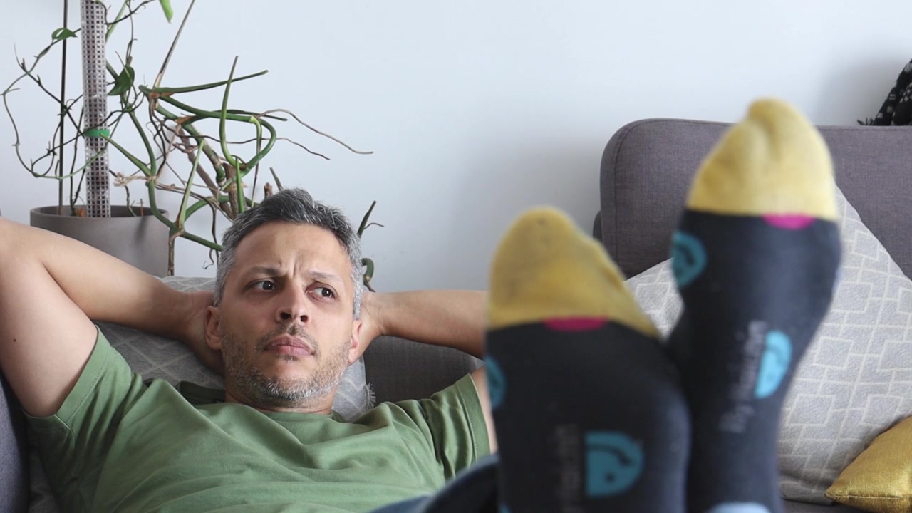 Uomo che si rilassa sul divano con i piedi in alto