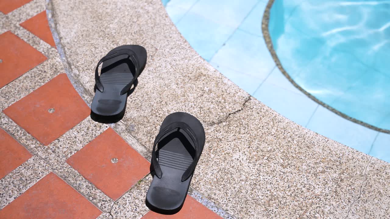 sandalias de nadador en el borde de una piscina