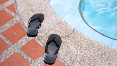 swimmer's sandals at the edge of a pool