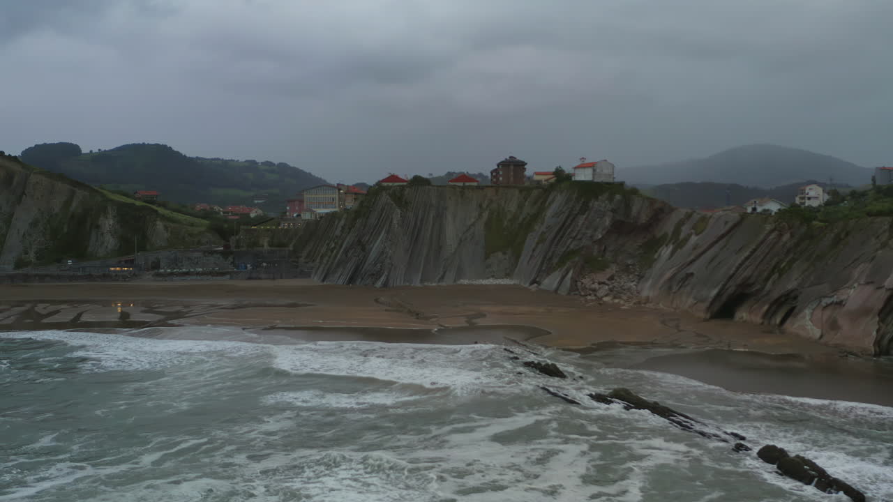 pan aerial acros itzurun playa en un día nublado tormentoso