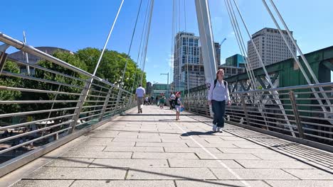 people walking on hungerford bridge in london