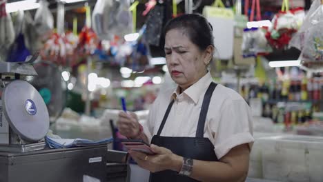 market vendor using mobile phone