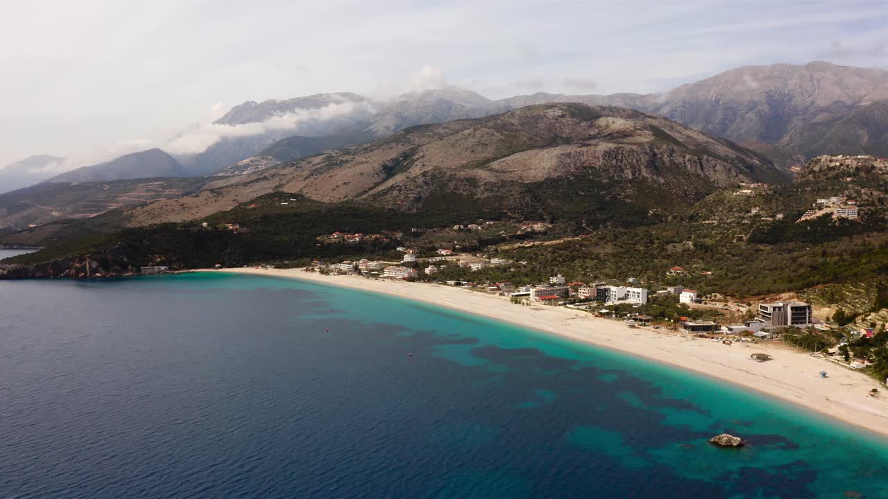 Aerial view of Himare beach on coast of Albania with mountains and sea