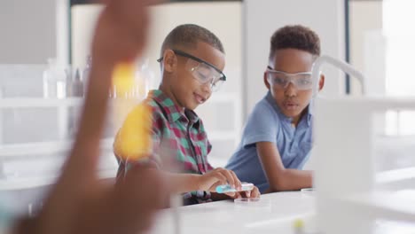 Video-of-happy-african-american-boys-wearing-glasses-during-chemistry-lesson