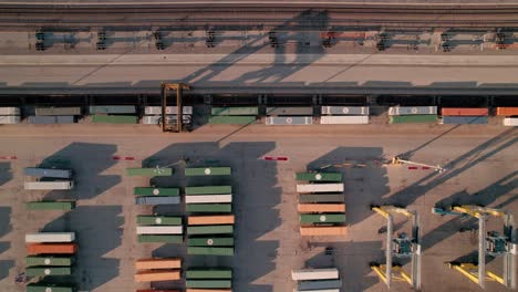 beautiful aerial of a container handler driving above lined up containers