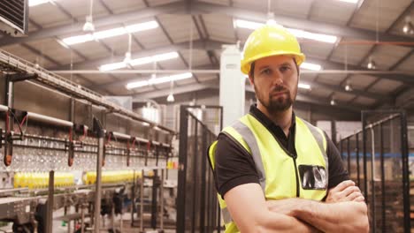 Worker-standing-with-arms-crossed-in-factory