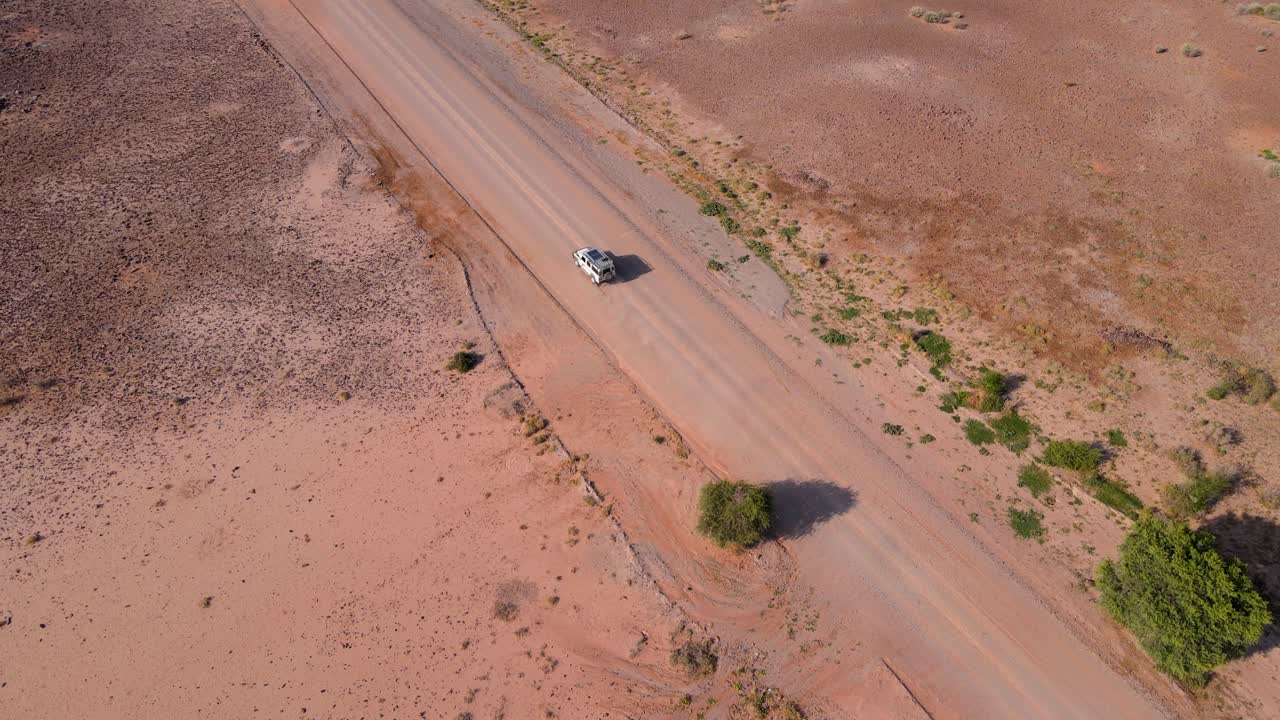 Aerial View of a Vehicle Driving on a Desert Road