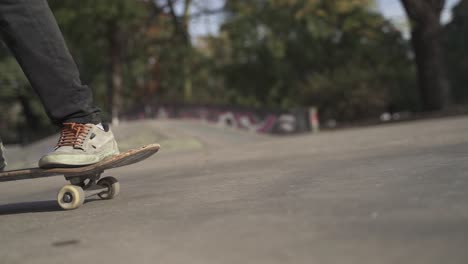 Toma-En-Cámara-Lenta-De-ángulo-Bajo-Del-Patinador-Saltando-Y-Golpeando-El-Suelo-Con-La-Tabla-Al-Aire-Libre-En-El-Parque-De-Patinaje