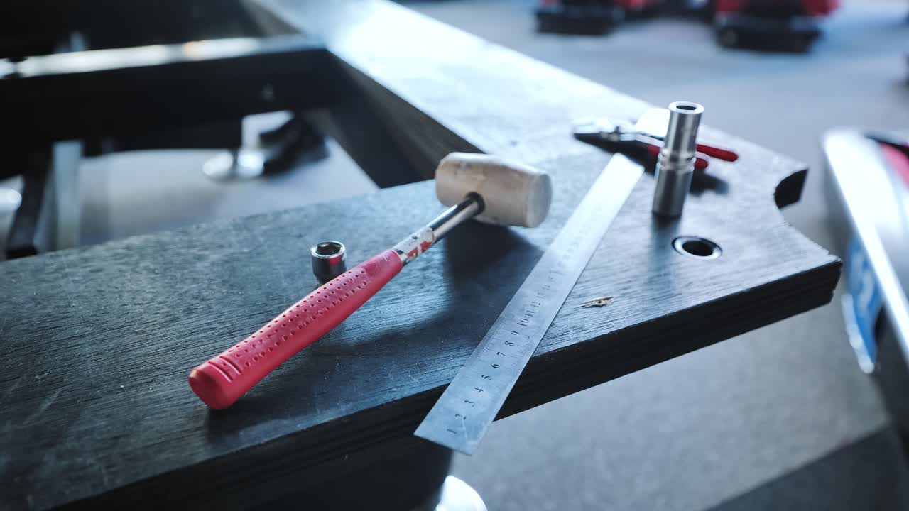Hammer, ruler, sockets placed for billiard slate alignment in workshop session