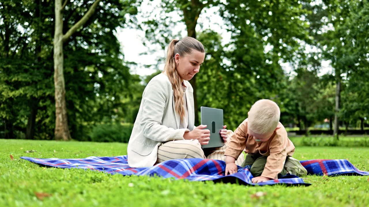 Mor sidder på græsset i parken, og hendes lille søn løber rundt. En kvinde arbejder fjernstyret på barselsorlov. En freelancemor arbejder online udendørs, mens hun går tur i parken.