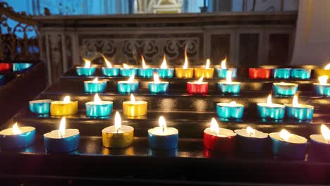 colorful candles burning in a catholic church in italy, europe