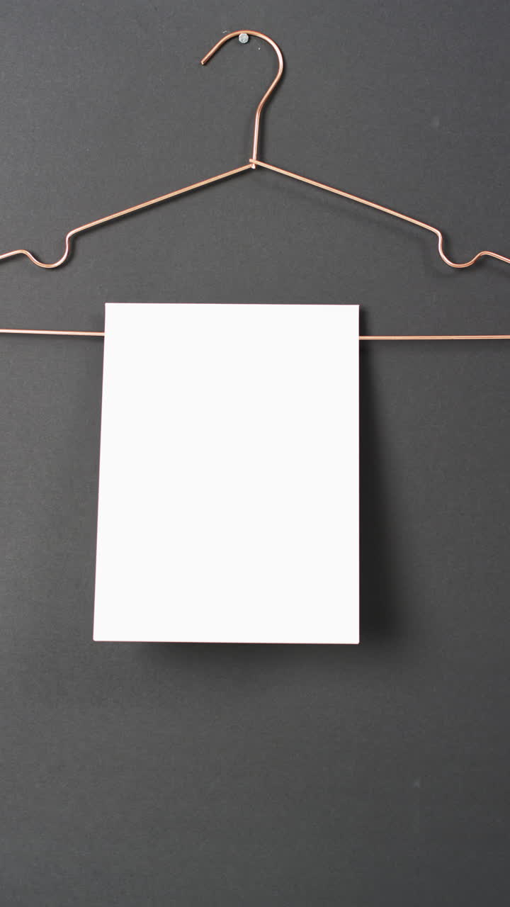 Video verticale di un libro con pagine bianche vuote appeso e spazio per il testo su sfondo nero.