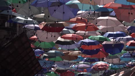 colorful umbrellas hanging in a city street