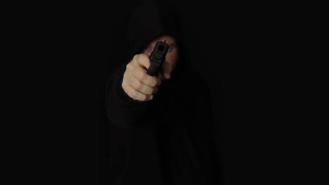 A-criminal-man-in-a-black-hood-pointing-hand-gun