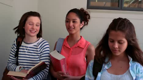 schoolgirls interacting with each other in corridor