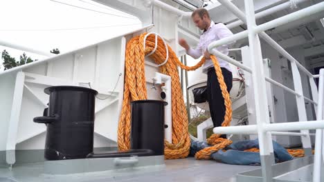 passenger ship captain coils and stores mooring rope before sailing