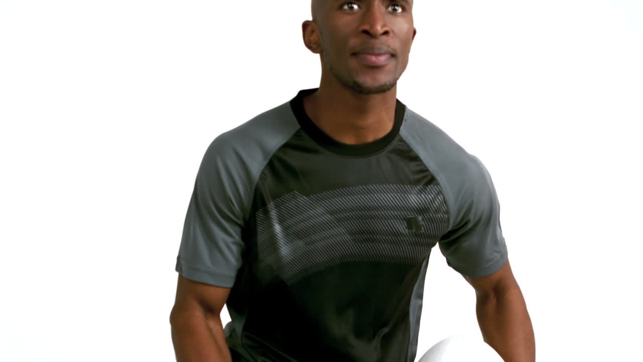 jugador de rugby serio corriendo y sosteniendo la pelota de rugby