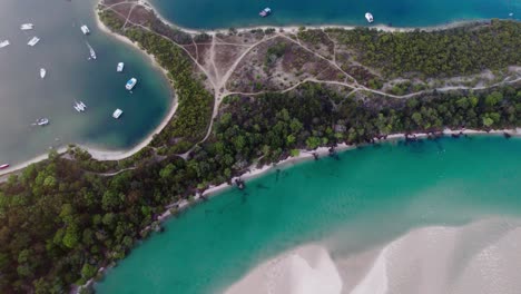 volando a través de la niebla y las nubes sobre la playa relajada con yates y veleros en la costa de noosa heads, qld, australia