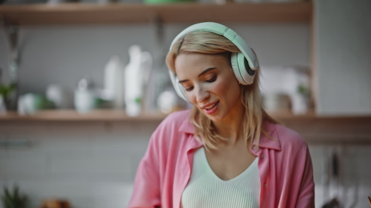 Unknown girl cutting vegetables on board kitchen closeup. Woman listening music