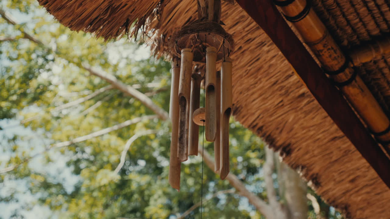 Bamboo Wind Chime Hanging from a Thatched Roof