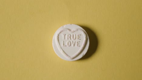 heart candy with true love message on yellow background