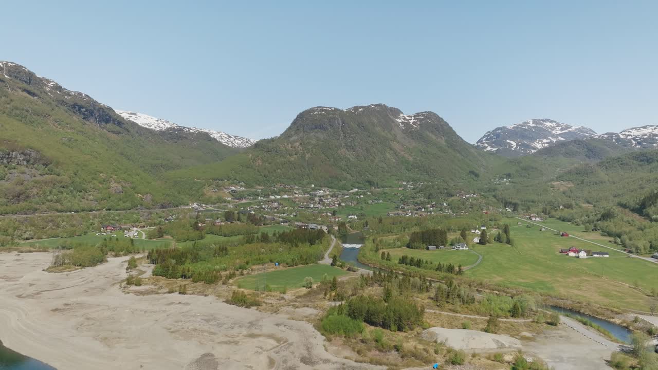 panorámica aérea de røldal en noruega, con montañas, vegetación y un cielo azul claro