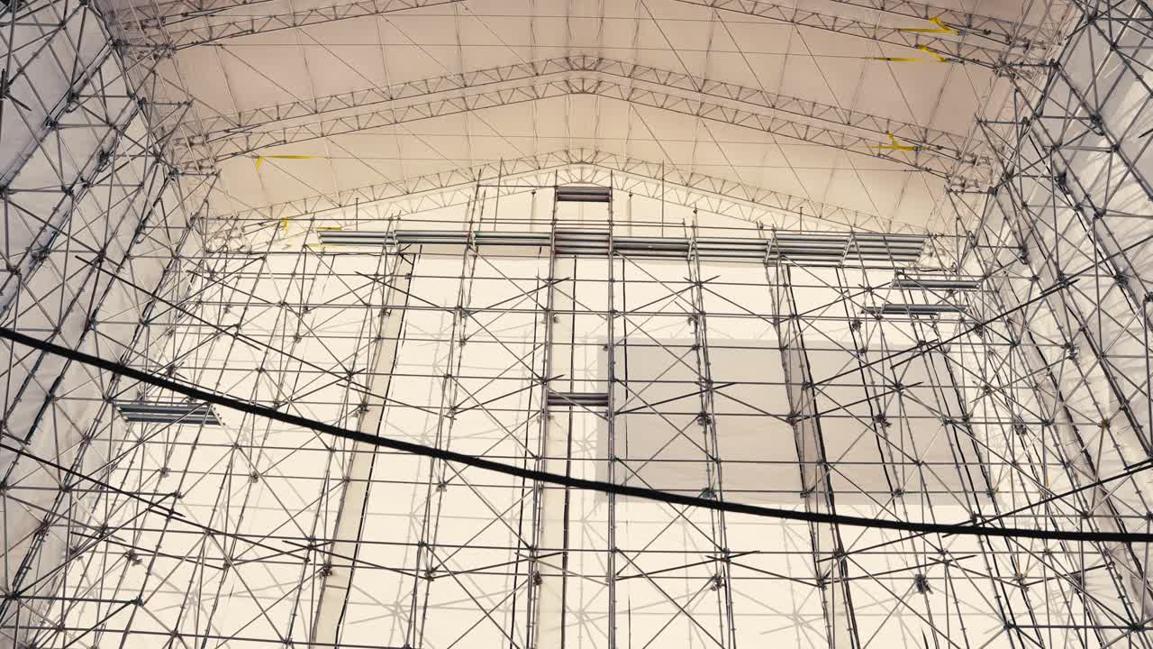 tiro de ángulo ancho inclinado de una gran estructura de tienda sostenida por un andamio que cubre un barco viejo