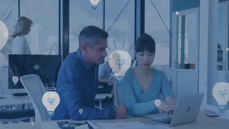animación de iconos de bombillas eléctricas sobre hombres y mujeres diversos discutiendo sobre una computadora portátil en la oficina