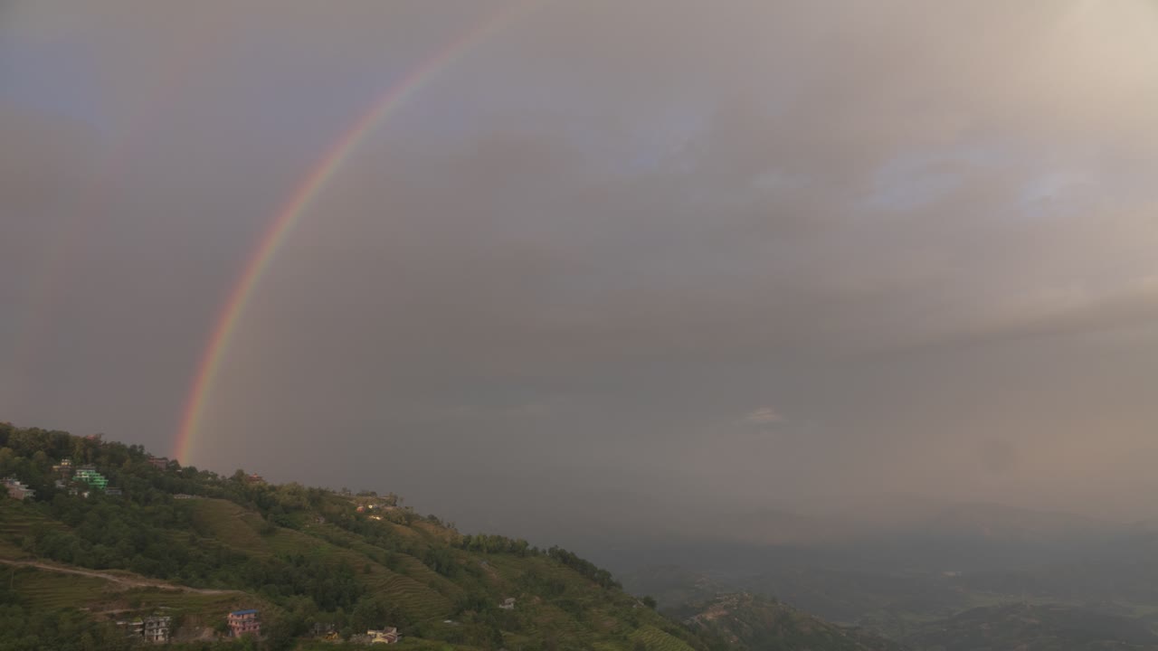 Rainbow over a mountain village at sunset