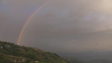 rainbow over a mountain village at sunset