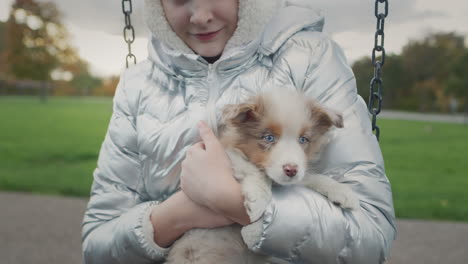 a girl snuggles a cute puppy, walks together in an autumn park