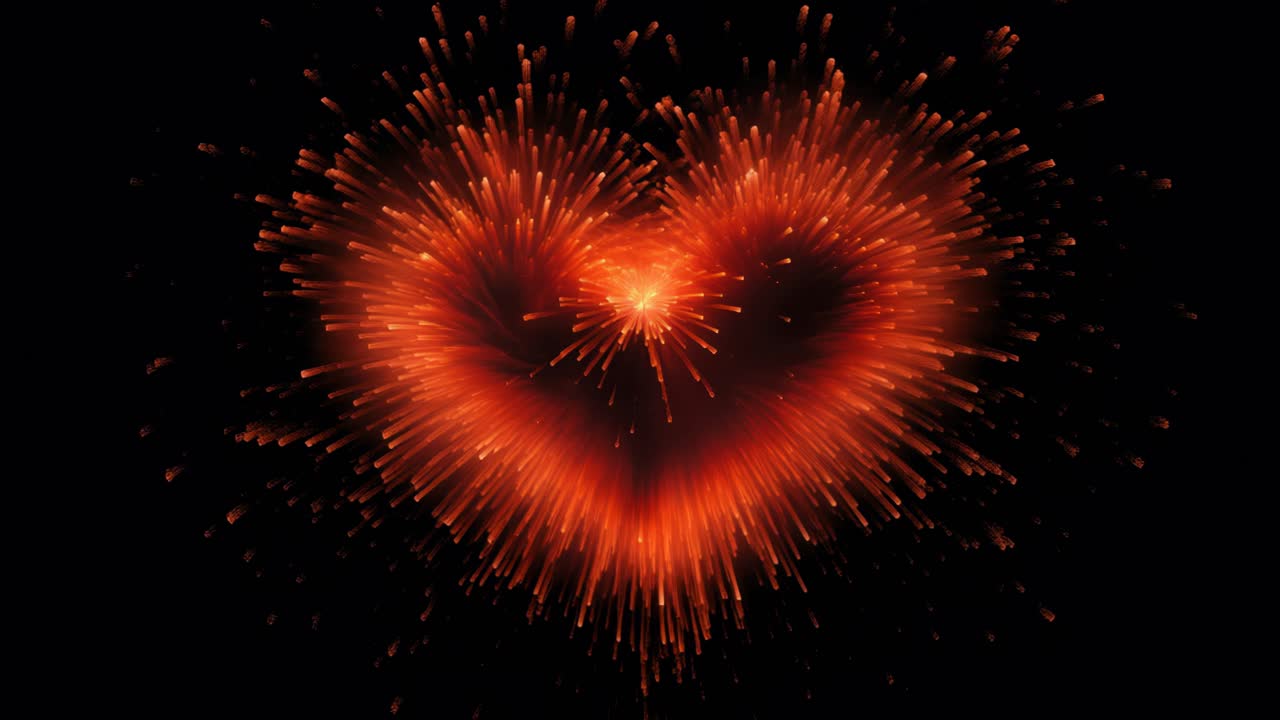 A heart-shaped firework explodes against a black background, captured from a front angle