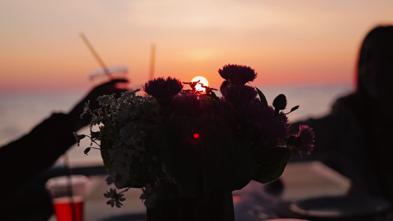Group of friends celebrating sunset on yacht with drinks in calm Baltic Sea