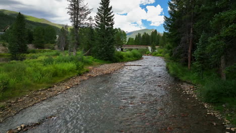 Keystone-River-Blue-fishing-golfing-peaceful-ski-resort-aerial-cinematic-drone-summer-Breckenridge-Colorado-Vail-resort-Epic-Pass-ski-snowboard-bike-biking-biker-bridge-path-slowly-backwards-motion