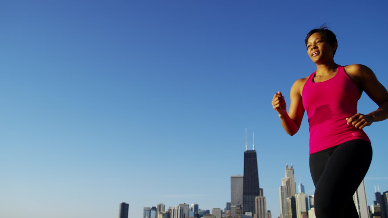 mujer afroamericana corriendo con un monitor de fitness inteligente