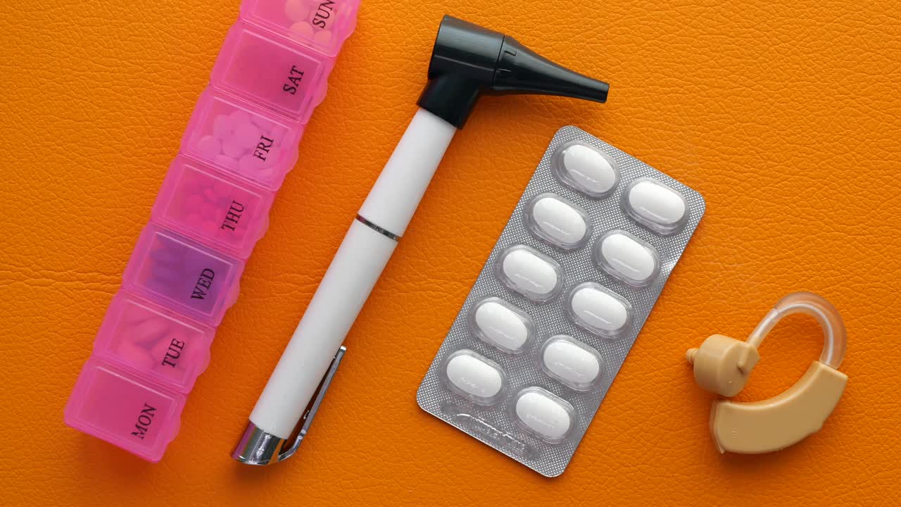 Høreapparatudstyr og medicinske piller på bordet