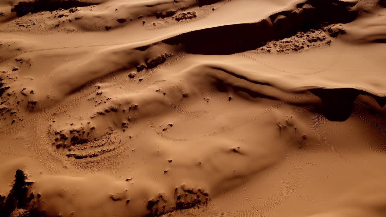 Abstract aerial perspective of sinuous lines and forms in the pink desert dunes of Utah.