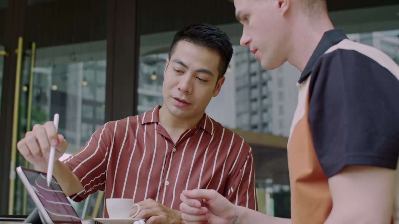 Specialist Teaching Young Entrepreneur How to Read Trading Chart on Tablet