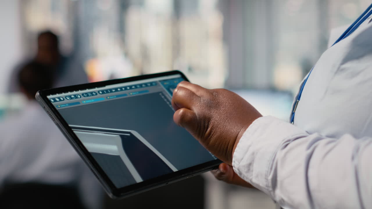 Close Up Of Technician Using Tablet To Create Solar Powered Device Design