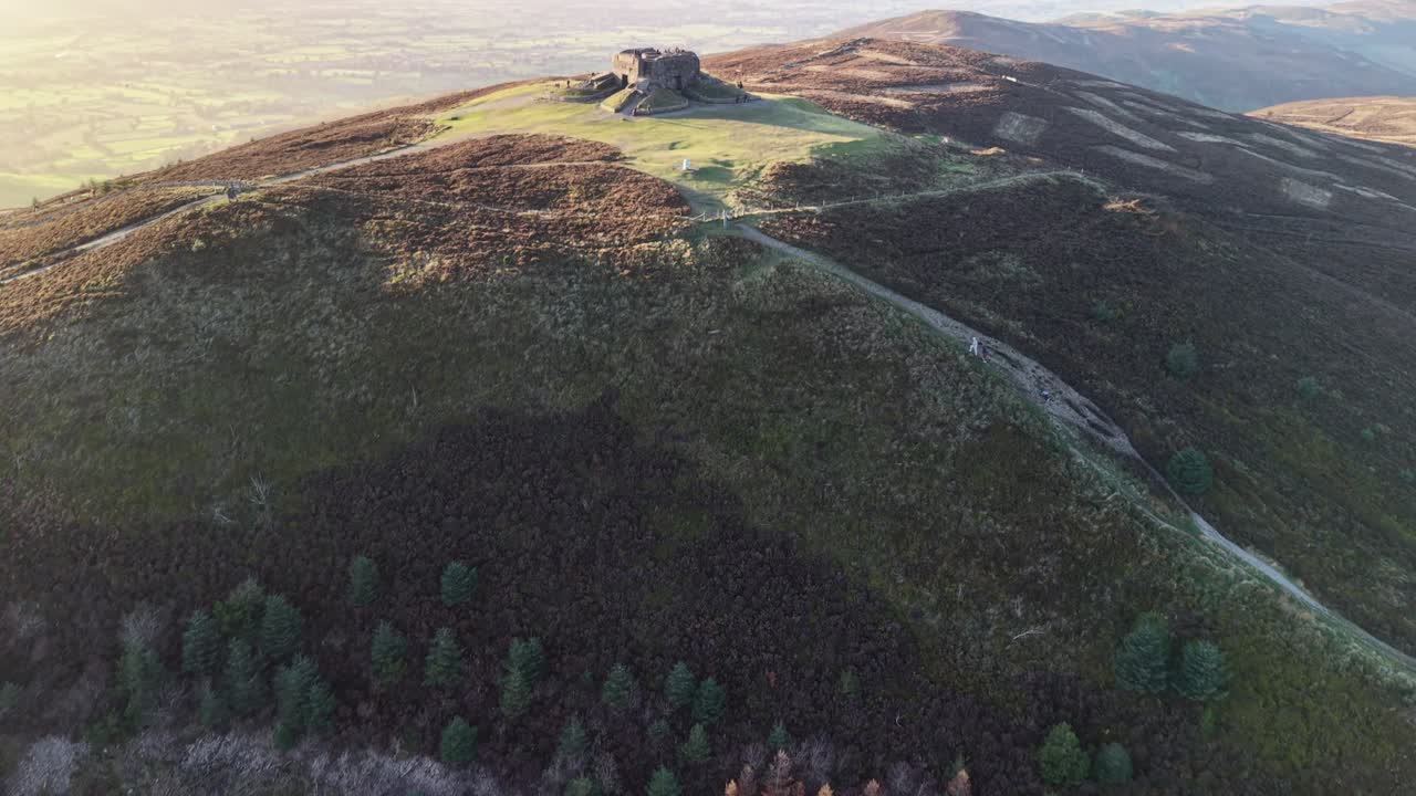 Moel Famau hill fort at sunset in high framerate and stunning HDR , North Wales, UK - drone gimbal down, then reveal Jubilee Tower