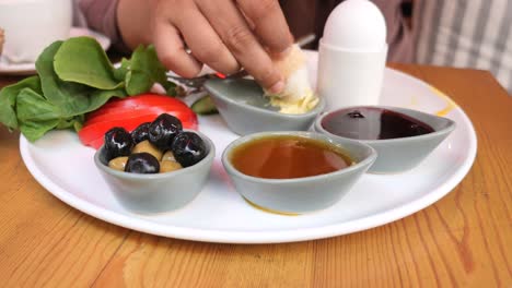 turkish breakfast with bread, olives, tomatoes, lettuce, egg, honey, butter and jam