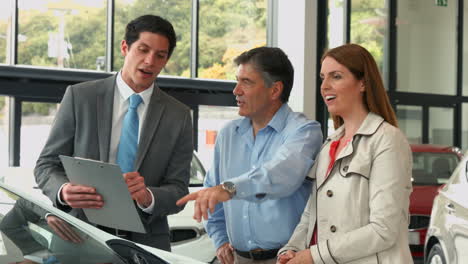 una pareja feliz discutiendo detalles del coche.