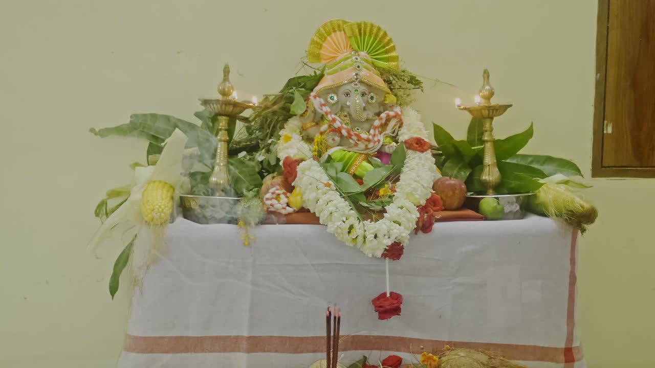 Indios celebrando Vinayaka Chavithi en una casa decorada con flores y frutas. Toma interior, toma estática, 4K