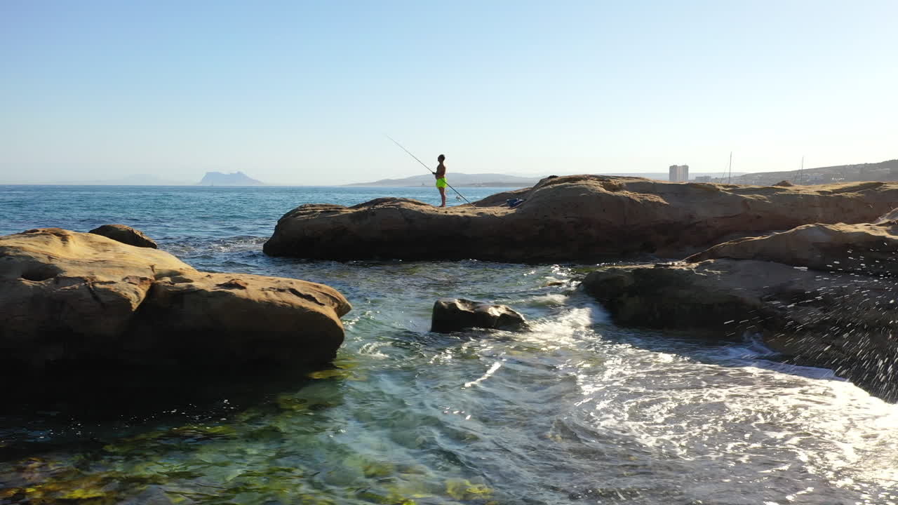 일부 바위에서 지중해를 낚시하는 남자의 실루엣, 패닝 샷