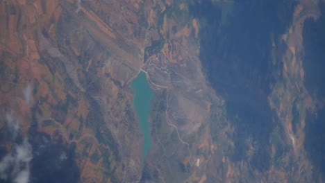 aerial view of a lake surrounded by mountains and countryside