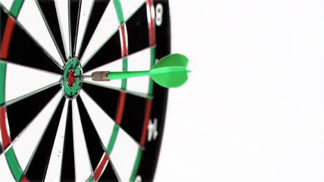 plastic green dart in super slow motion being thrown on a dart board