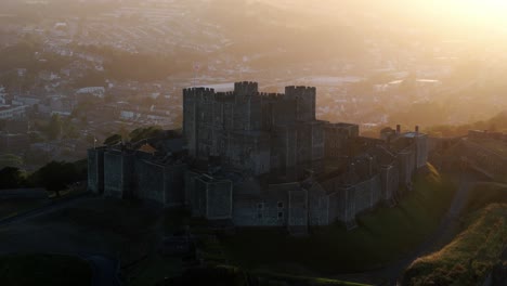 slow drone orbit around dover castle reveals stone walls and surrounding green terrain, medium establishing